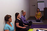 Four women sitting on the floor doing mindulness yoga